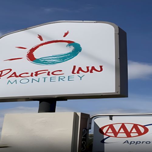 Pacific Inn sign with a stylized sun logo; &ldquo;Monte rey&rdquo; text visible, plus a AAA Approved sign nearby.